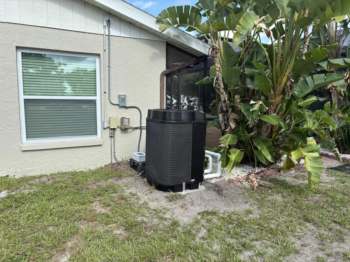 Pool heat pump installed outside a screened lanai in Southwest Florida