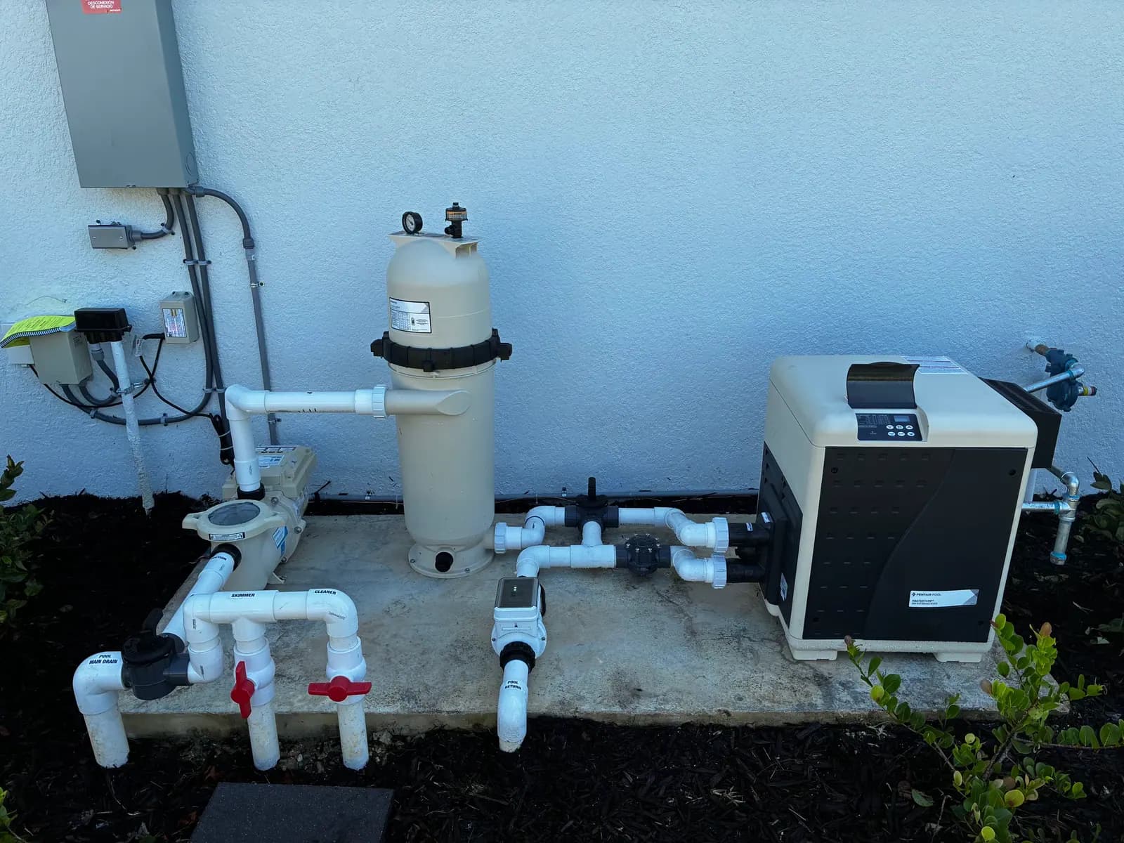 Pentair MasterTemp gas pool heater on a concrete pad with a cartridge filter, pump and labeled PVC valves